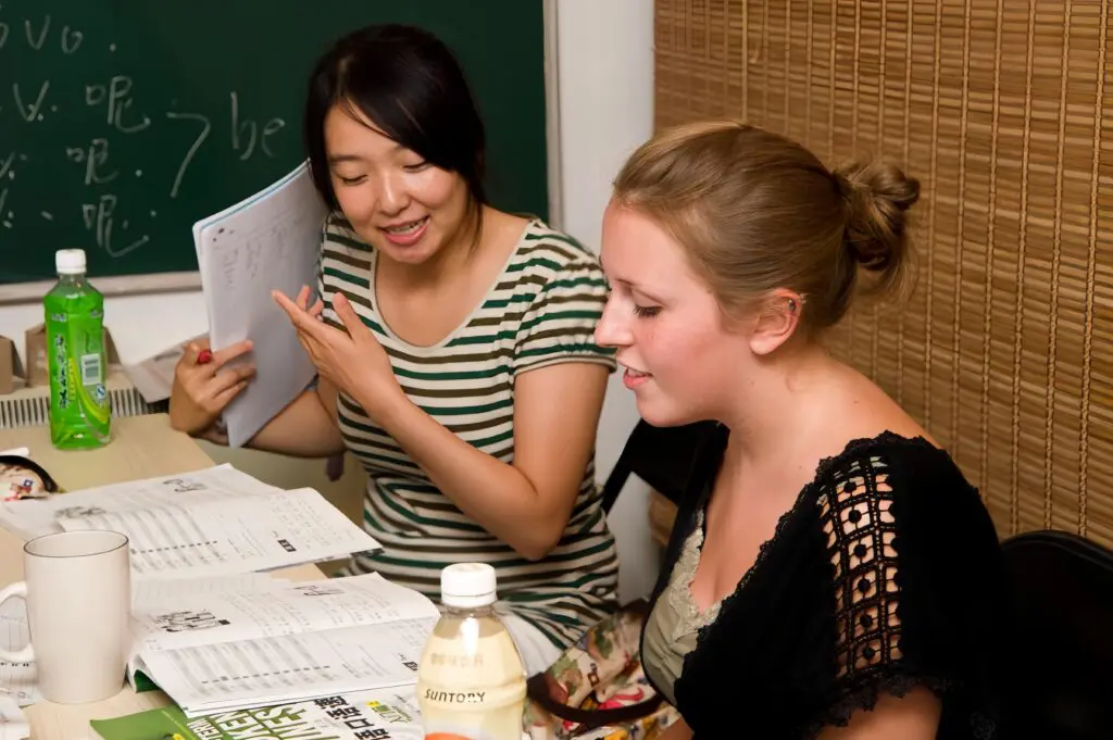 Expert Mandarin tutor guiding an international student through HSK mock papers at Nihao Language Education in Hong Kong.
