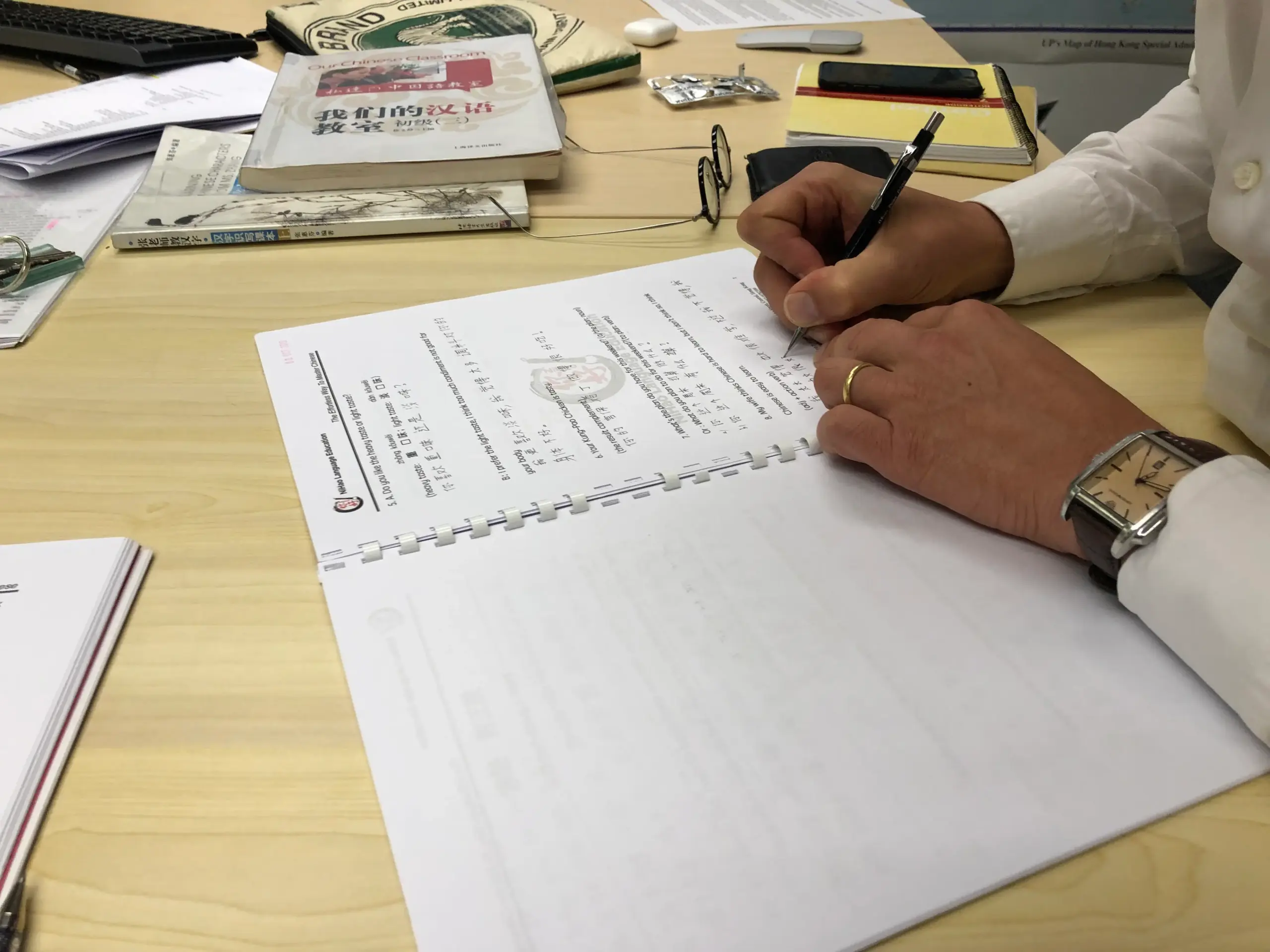 Student handwritten Chinese character practice, pinyin annotation, and professional teacher correction in Nihao Language Education's Mandarin class in Hong Kong