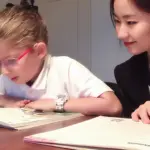 Native Mandarin Master tutor guiding an international school student through focused textbook reading and pronunciation practice in Hong Kong.