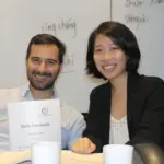 Expatriates and working adults participating in a collaborative small-group Conversational Mandarin session at Nihao Language Education Central campus, using proprietary coursebooks in an engaging classroom setting.